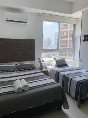 two beds in a room with a window at Eliptic Cartagena-Oceano in Cartagena de Indias