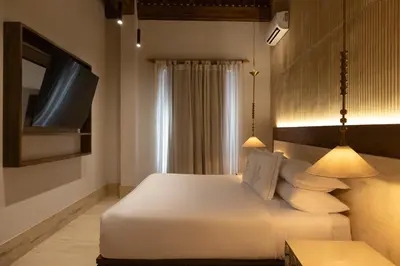 a bedroom with a white bed and a tv at Hotel Palacio del Agua by Faranda Boutique in Cartagena de Indias
