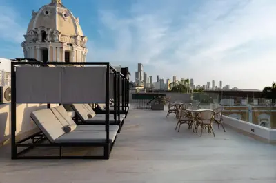 a balcony with chairs and a table and a building at Hotel Palacio del Agua by Faranda Boutique in Cartagena de Indias