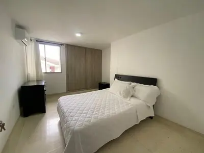 a bedroom with a bed with white sheets and a window at Your ideal stay in Barranquilla awaits