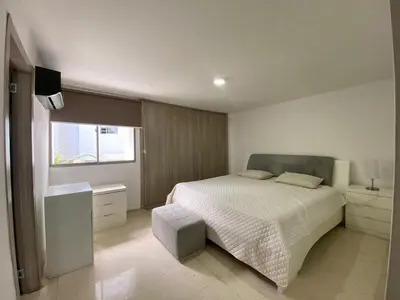 a white bedroom with a bed and a window at Your ideal stay in Barranquilla awaits
