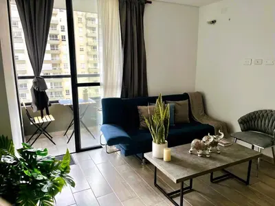 a living room with a blue couch and a table at New and Modern Loft in exclusive northern area in Barranquilla