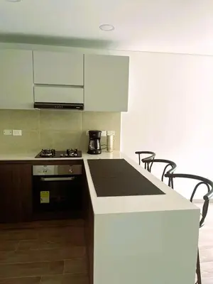 a kitchen with white cabinets and a counter top at New and Modern Loft in exclusive northern area in Barranquilla
