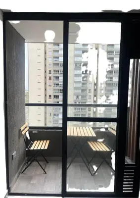 a balcony with two chairs and a view of a building at New and Modern Loft in exclusive northern area in Barranquilla