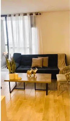 a living room with a blue couch and a coffee table at New and Modern Loft in exclusive northern area in Barranquilla