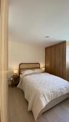 a bedroom with a large bed with a wooden headboard at Minimalist and cozy apartment in Barranquilla