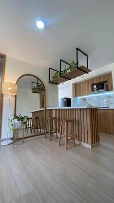 a kitchen with a bar with stools in a room at Minimalist and cozy apartment in Barranquilla