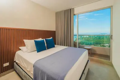 a bedroom with a large bed with a large window at Apartment on the 21st floor, ocean and Sierra views in Simón Bolivar