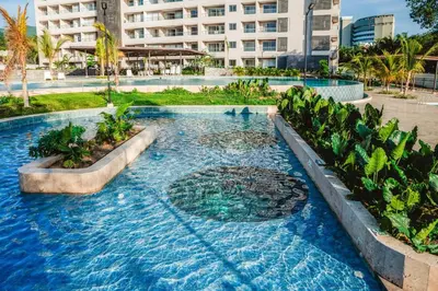 a swimming pool with blue water in a resort at Apartment on the 21st floor, ocean and Sierra views in Simón Bolivar