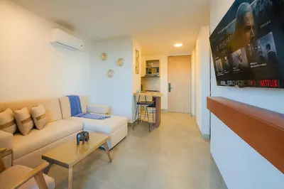a living room with a white couch and a table at Apartment on the 21st floor, ocean and Sierra views in Simón Bolivar