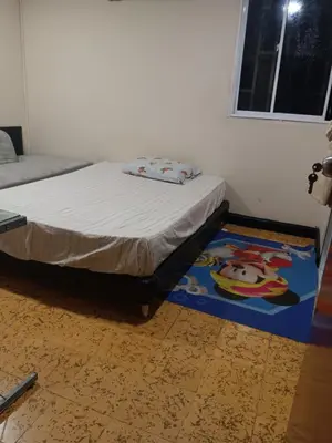a bedroom with a bed and a rug on the floor at Hostal Mr Key in Barranquilla