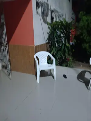 a white chair sitting on the side of a building at Hostal Mr Key in Barranquilla