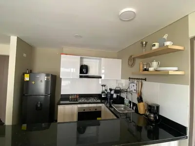 a kitchen with a black and white refrigerator at Exclusive oasis , Beach, pool and high comfort in Serena del Mar