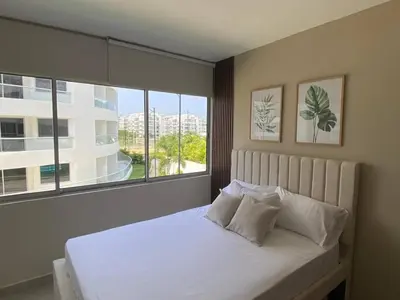 a bedroom with a white bed with a large window at Exclusive oasis , Beach, pool and high comfort in Serena del Mar