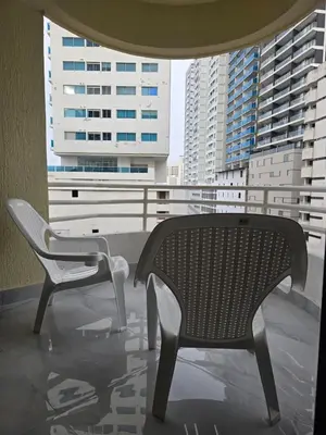 a bench and chairs on a balcony with buildings at Apartment in El Cabrero in Cartagena de Indias