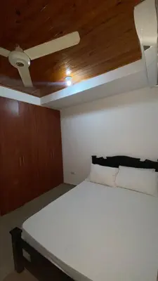a white bed in a room with a wooden ceiling at GUILLOTE Comfort Loft in Cartagena de Indias