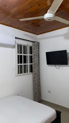 a bedroom with a bed and a flat screen tv at GUILLOTE Comfort Loft in Cartagena de Indias