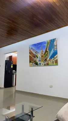 a painting of buildings on a wall with a glass table at GUILLOTE Comfort Loft in Cartagena de Indias