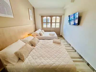 a bedroom with two beds and a tv on the wall at Hotel Casa Obed in Cartagena de Indias