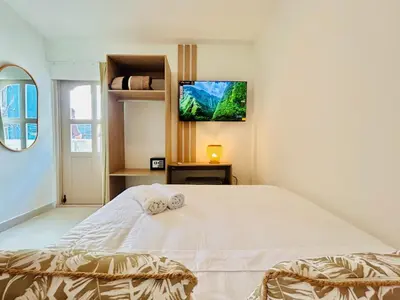 a bedroom with a white bed with a tv on the wall at Hotel Casa Obed in Cartagena de Indias