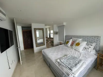 a bedroom with a large bed and a television at Oceanfront Oasis in Cartagena de Indias