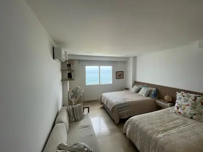 a hotel room with two beds and a couch at Oceanfront Oasis in Cartagena de Indias