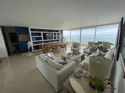 a living room with couches and a dining room with the ocean at Oceanfront Oasis in Cartagena de Indias