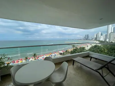 a balcony with a table and chairs and the ocean at Oceanfront Oasis in Cartagena de Indias