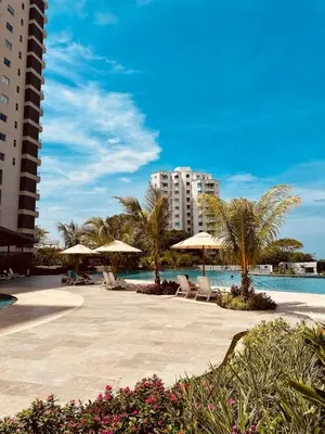 a resort with a pool and chairs and umbrellas at Apartamento Bohemio frente al Mar en Santa Marta in Santa Marta