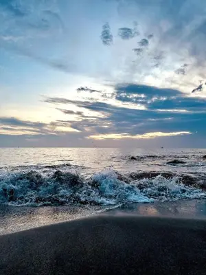 a beach with the ocean and a cloudy sky at Apartamento Bohemio frente al Mar en Santa Marta in Santa Marta
