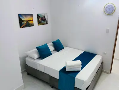 a bedroom with a bed with blue and white pillows at Hospedaje Torices Cartagena in Cartagena de Indias