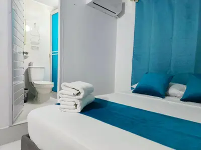 a blue and white bathroom with a bed and a toilet at Hospedaje Torices Cartagena in Cartagena de Indias