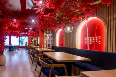 a row of tables in a restaurant with red flowers at Berthas collection by em hotels in Cartagena de Indias
