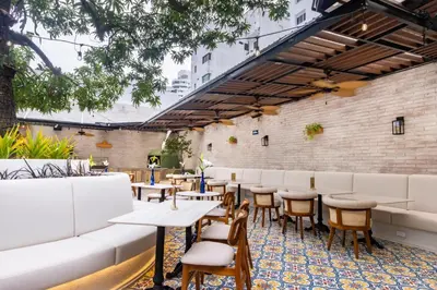 a restaurant with tables and chairs and a brick wall at Berthas collection by em hotels in Cartagena de Indias