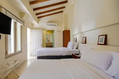 a bedroom with two beds and a flat screen tv at Casa Stella - Authentic Luxury Rooftop Pool in Cartagena de Indias