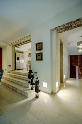 a living room with stairs and paintings on the wall at Casa Stella - Authentic Luxury Rooftop Pool in Cartagena de Indias