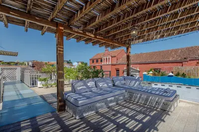 a patio with a blue couch on a roof at Casa Stella - Authentic Luxury Rooftop Pool in Cartagena de Indias