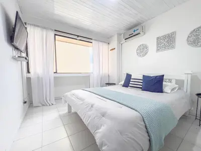 a bedroom with a large bed with blue and white sheets at Tropical Beach - Con vista al mar in Cartagena de Indias