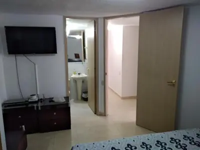 a room with a bed and a television and a bathroom at Apartamento 3 alcobas barrio Miramar Barranquilla in Barranquilla