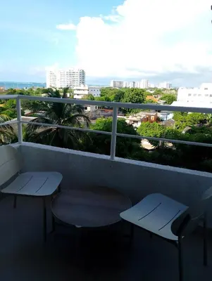 a balcony with two chairs and a view of a city at Apartamento moderno cerca de la playa in Cartagena de Indias
