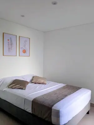 a bedroom with a bed with two pictures on the wall at Apartamento moderno cerca de la playa in Cartagena de Indias