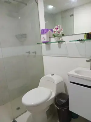 a white bathroom with a toilet and a sink at Oceanfront apartment in Cartagena de Indias