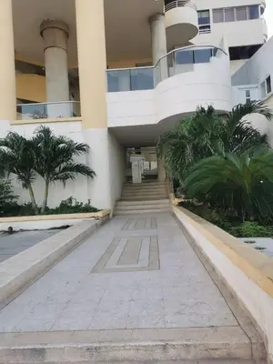 a building with stairs and palm trees in front of it at Oceanfront apartment in Cartagena de Indias
