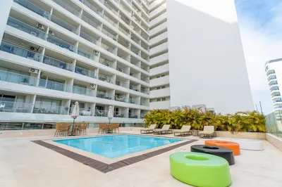 an apartment patio with a swimming pool and a building at Olas & relax Cartagena in Cartagena de Indias