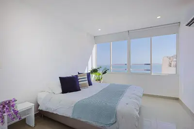 a bedroom with a bed and a large window at Riviera Suite - Apartamento con balcón in Cartagena de Indias