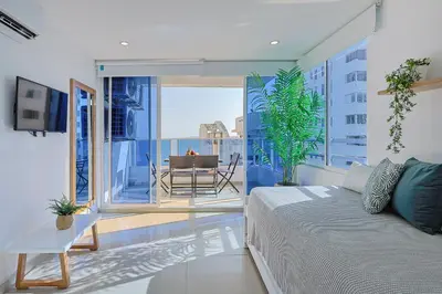 a bedroom with a bed and a balcony with a table at Riviera Suite - Apartamento con balcón in Cartagena de Indias