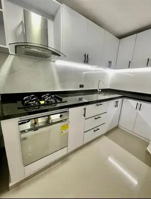 a kitchen with white cabinets and a stove top oven at Apartment in Barranquilla in Barranquilla
