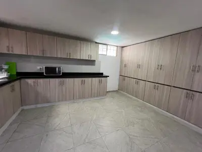 a large kitchen with wooden cabinets and a tile floor at Casa Mansion in Barranquilla