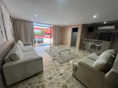 a living room with two couches and a kitchen at Casa Mansion in Barranquilla