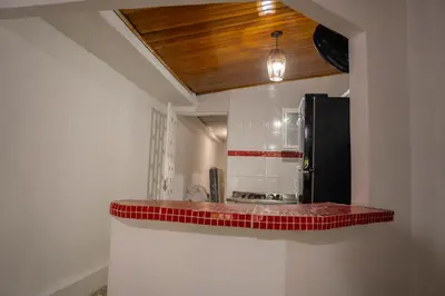 a kitchen with a counter top with red tiles at Cabaña Playa Azul in Coveñas